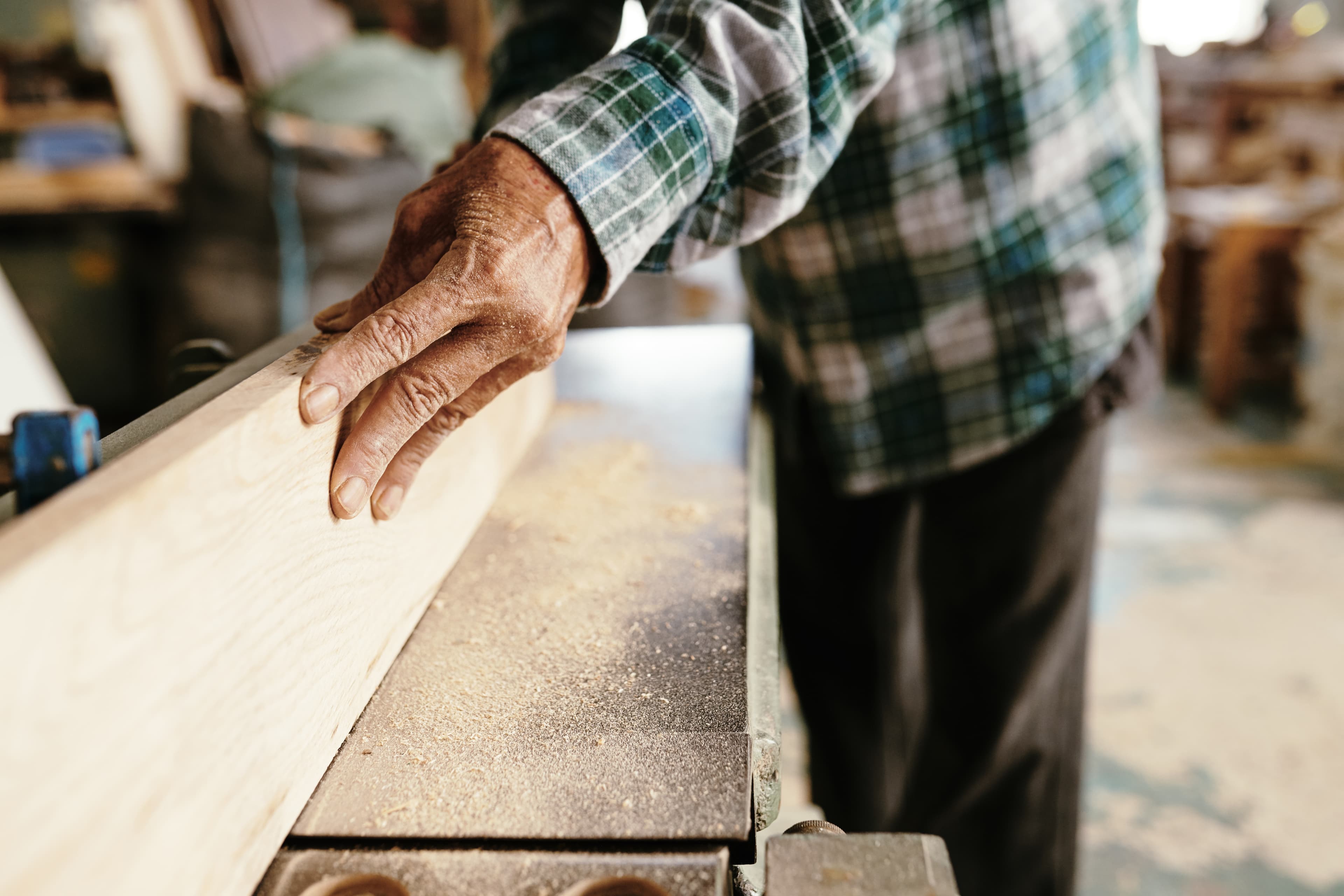 Manos trabajando una pieza de madera.